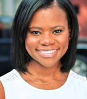 Ashleigh wears a side part of hair and a white round neck top