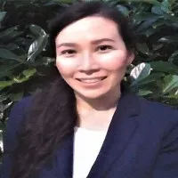 Caitlin Kay smiles at camera wearing a dark blazer and a white top.