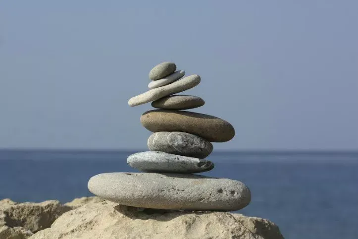 Rocks placed in a pile, a cairn, with a large body of water in the background