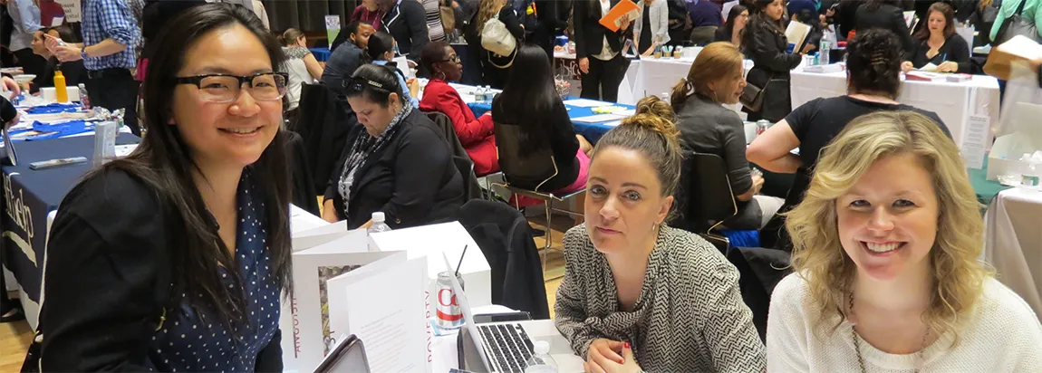 Three women candidates smile into camera during a Recruitment Event