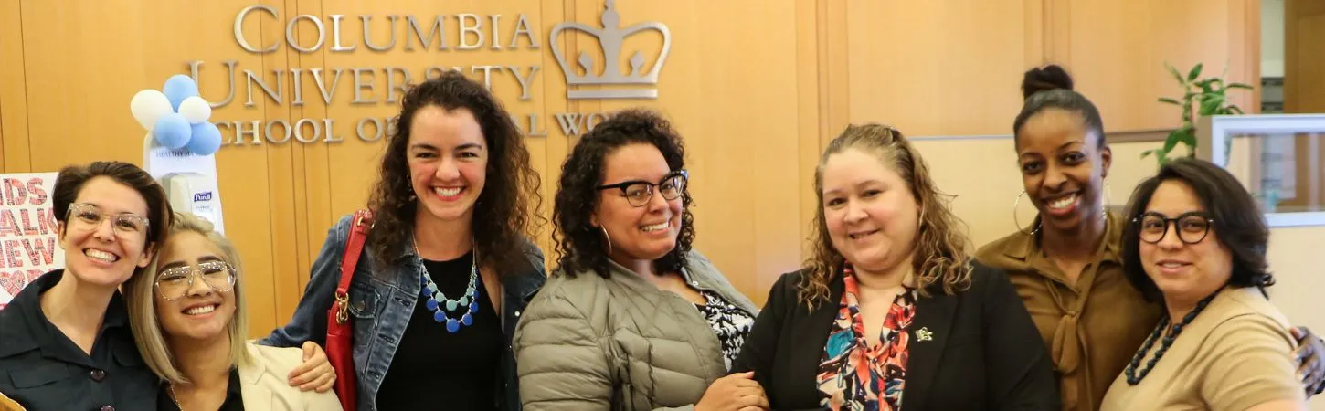 Smiling cssw students in the social work building's lobby.