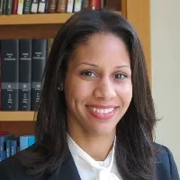 Professor Carmela Alcantara smiles wearing a dark blazer and white blouse