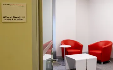 Entryway of DEI office reveals two leather seats positioned behind a white table