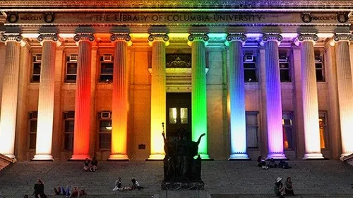 The pillars of Low Library are illuminated by the multi colored lights of the pride community. 