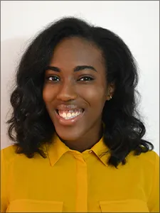 Kyra Russell wears a smile and golden-yellow blouse. 
